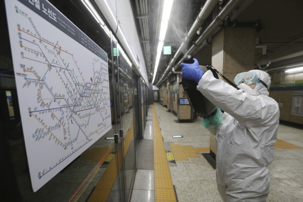 Agente usa desinfetante spray em estação de metrô em Seul